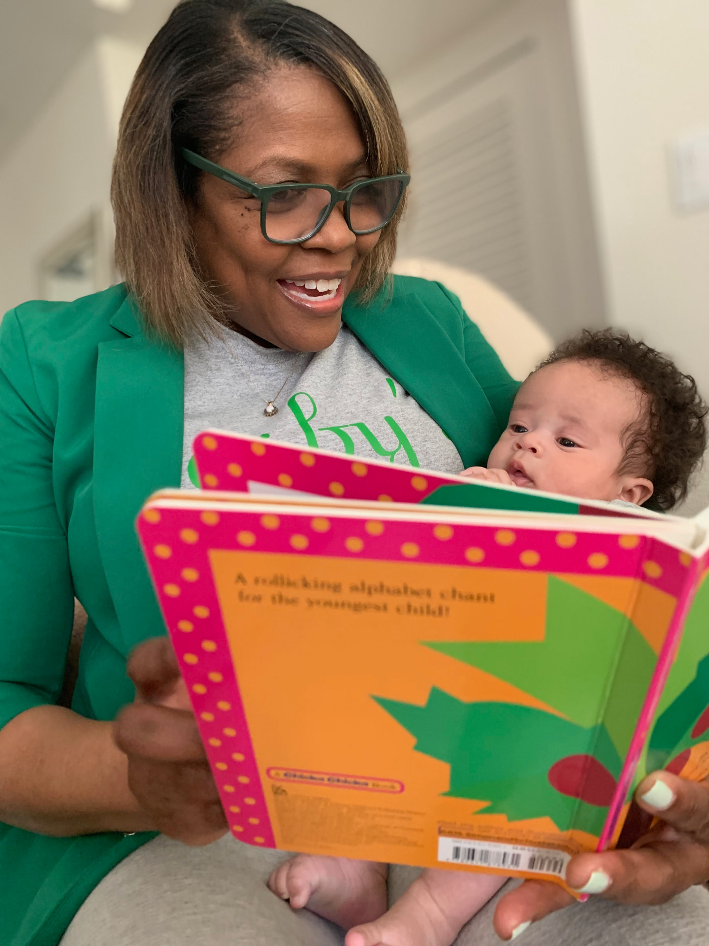Gasby reading a picture book with an infant
